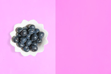 Large fresh garden berries blueberries, white plate with copy space for text on a colored background. The concept of vegetarian and healthy summer food. 
