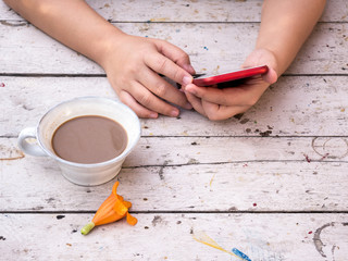 Woman hand holding smartphone with cup of coffee and yellow flower on wooden desk. - Powered by Adobe