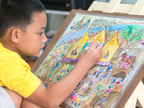 The asian kid drawing and painting his art, watercolor and pencil color on paper.