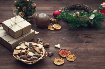 Top  view  of Christmas background. Christmas presents,cookies and dry oranges on a brown wooden table.