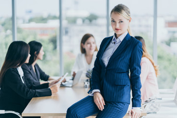 smart and relax beautiful caucasian manager woman in blue suit standing in meeting conference room