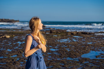 A young woman on a rocky cosmic Bali shore