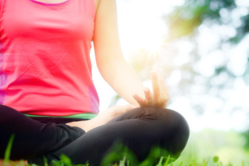 Yoga woman meditating on the grass in the morning, sunshine time, health concept.