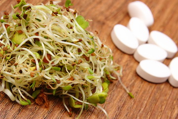 Alfalfa and radish sprouts with tablets supplements, choice between healthy eating and pills