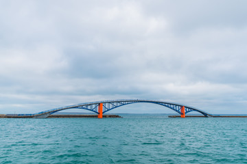 Blue and orange bridge on the ocean
