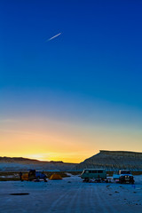 The wonderful views at sunset above the white cliffs of the shore of Tuzbair salt dry lake,...