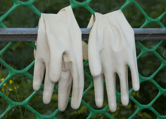 A pair of protective gloves for working in the garden, turned inside out, dried on the grate