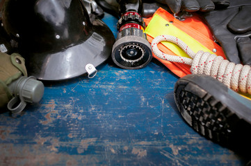 Outfit of Firefighter placed on old table background, Fire equipment concept.