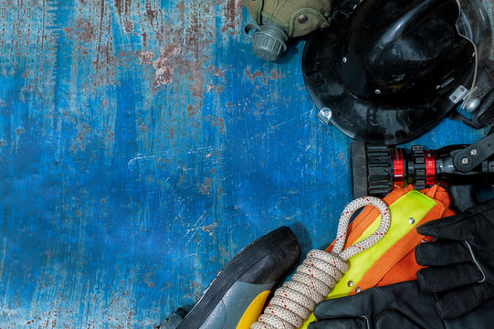 Outfit of Firefighter placed on old table background, Fire equipment concept.