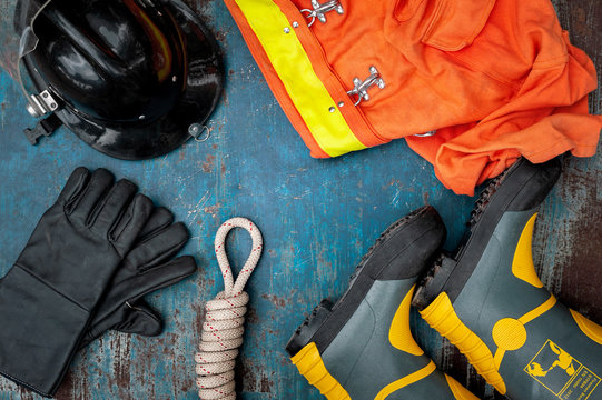 Outfit of Firefighter placed on old table background, Fire equipment concept.
