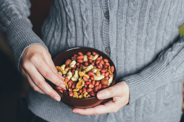 Woman holding a bowl of a mixture of nuts