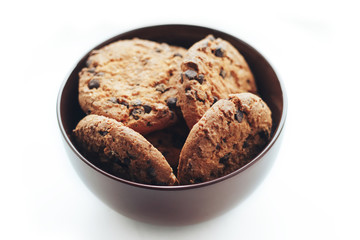 Chocolate cookies in a brown bowl on a white background