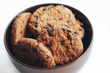 Chocolate cookies in a brown bowl on a white background