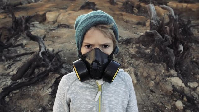 Environmental pollution, ecological disaster, nuclear war, post apocalypse concept. Care for future generations. Child in protective mask, face-guard to prevent breathing toxic air.