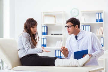Obraz premium Doctor examining patient with broken leg