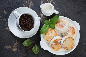Above view of cottage cheese pancakes with coffee on a brown stone background, horizontal shot