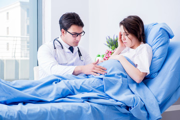 Doctor visiting pregnant in hospital room