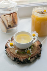 cup of herbal chamomile tea with camomile blossoms, honey in jar. doctor treatment and prevention of immune concept, medicine - folk, alternative, complementary, traditional medicine