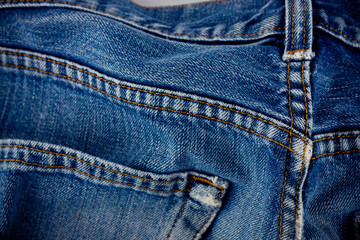 old blue jeans seam detail cloth of denim for pattern and classic background close up
