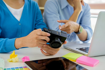 Graphic designers are looking at the camera at work.