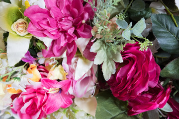 Obraz premium Beautiful multicolored artificial flowers background. Fake fabric flowers decor.