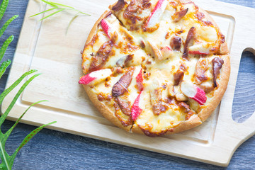 Delicious pizza baked on wooden board
