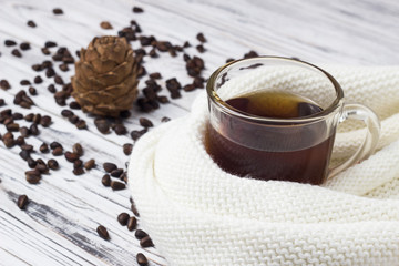 A cup of tea and pine nuts with a cone on a white wooden background, close-up, nuts and cedar