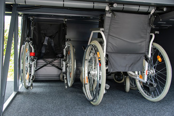 Barrierefreies Reisen im Reisebus, Rollstühle werden im Gepäckraum des  Reisebus verstaut
