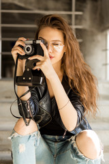 Photo of young cheerful woman in fashion transparent glasses wearing a rock black style leather...