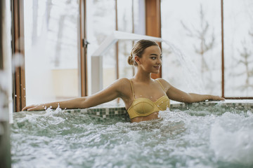 Pretty young woman relaxing in the bubble bath pool