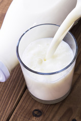 Dairy products. Bottle with milk and glass of milk on wooden table