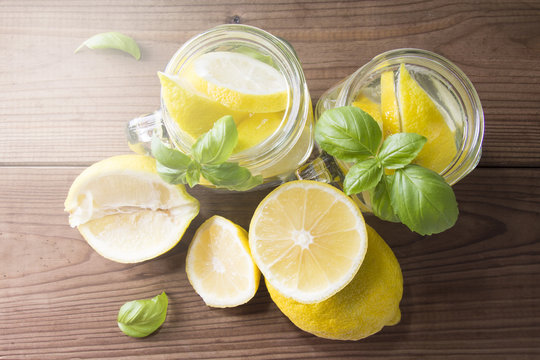 homemade refreshing summer lemonade drink with lemon slices and ice in mason jars
