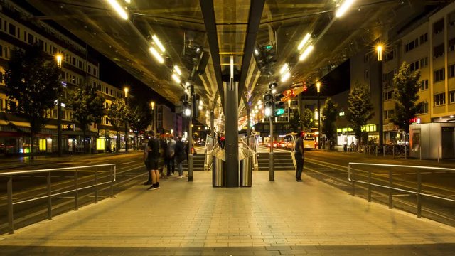 People crossing the street at night at a tram stop in Bonn, Germany