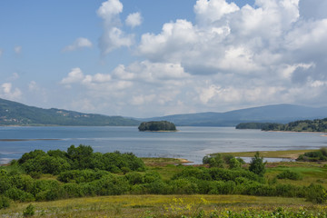 Beautiful cloudy sky over the mountain lake. Vlasina lake in eastern Serbia
