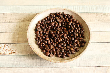 Coffee beans lying on small plate. Appetite for coffee. 