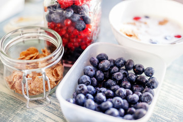 A bowl of fresh blueberries on the table, wheat flakes and homemade yogurt, healthy vitamin breakfast, detox, summer berries