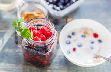 Glass jar with raspberries and other fresh berries on the table, healthy vitamin breakfast, detox, summer berries