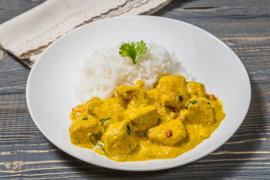 Chicken curry with rice on a dark background.