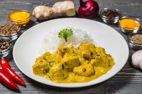 Chicken curry with rice on a dark background.