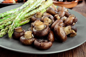 asparagus and toasted mushrooms on rustic wooden board