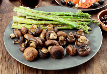 asparagus and toasted mushrooms on rustic wooden board