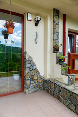 Wall with decorative masonry, forged thermometer and hanging flower vases