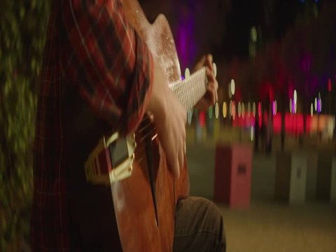 Playing acustic guitar in the streets at night
