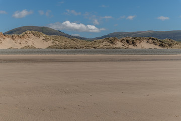 Sandy beach with sand dunes and distant hills