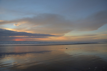 Fototapeta na wymiar Spiegelung im Wasser am Sandstrand in Muriwai Beach