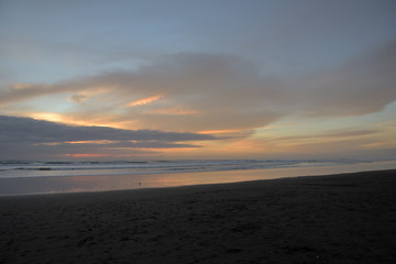 Spiegelung im Wasser am Sandstrand in Muriwai Beach