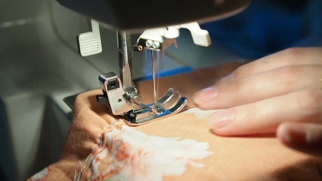 seamstress sews behind the machine close-up