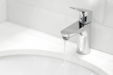 chrome crane on the ceramic wash basin in the bathroom close up
