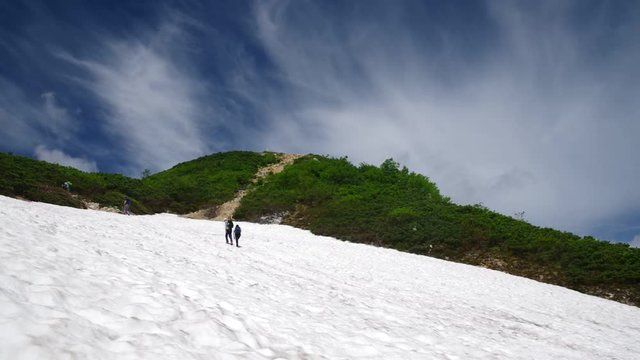 雪渓を登る登山者（北アルプス）