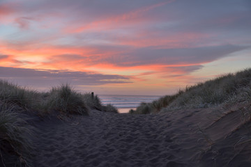 Muriwai Beach im Abendrot hinter den D&uuml;nen